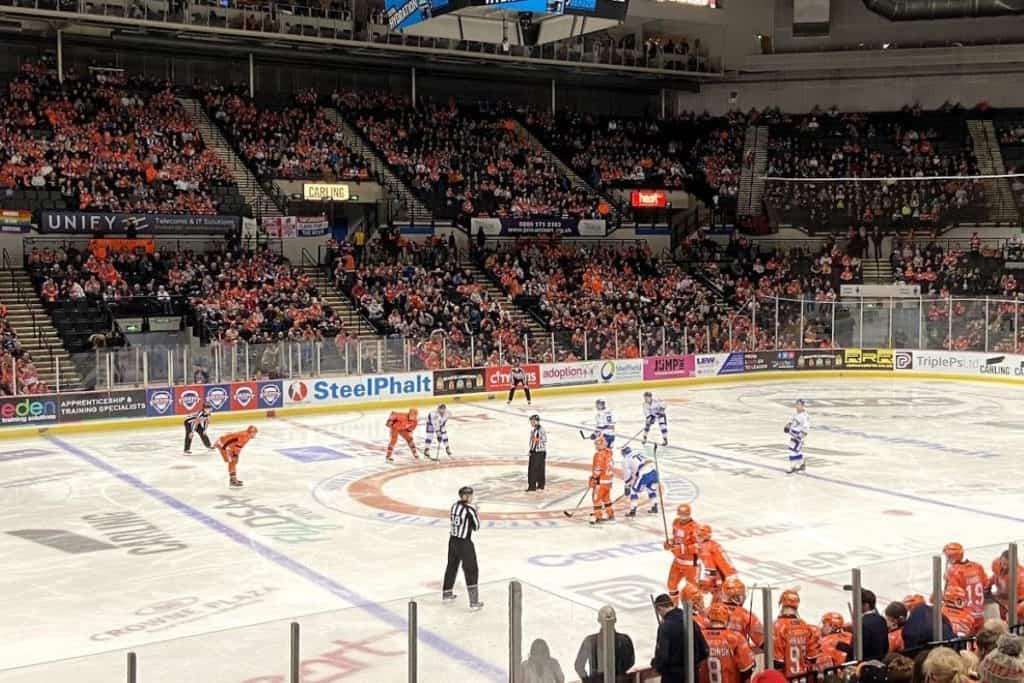 The sheffield steelers play the fife flyers while two referees and two linemen enforce ice hockey rules uk for the game